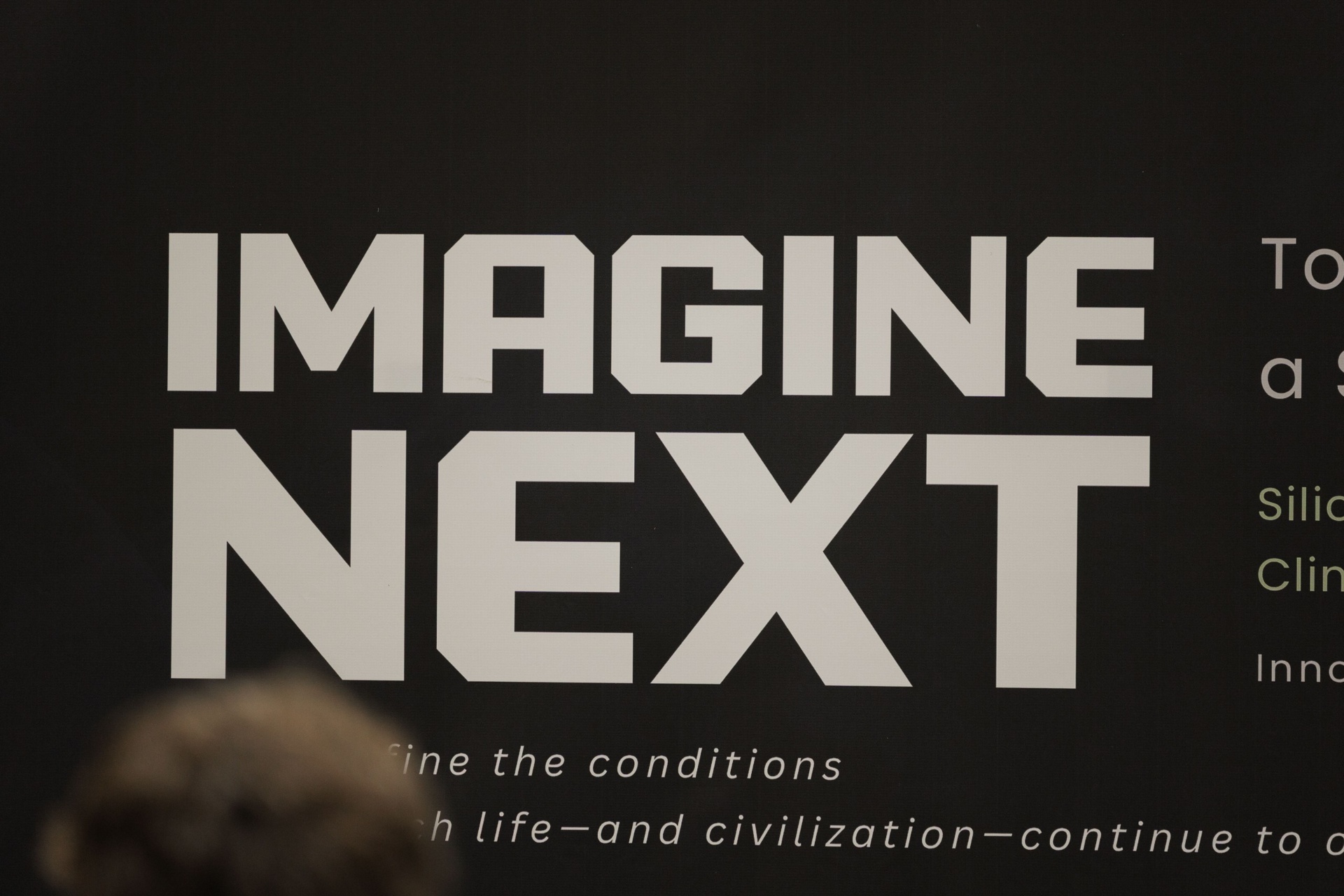 Close-up of the Imagine Next Capital Day banner typography — 'It will define the conditions under which life — and civilization — continue'