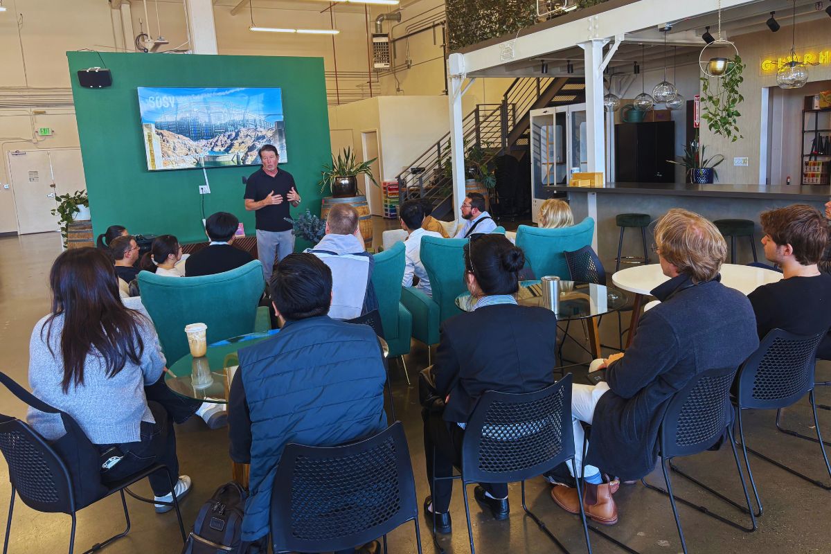 SOSV host gesturing while presenting to founders and investors seated in teal armchairs during the Frontiers Day visit in San Francisco