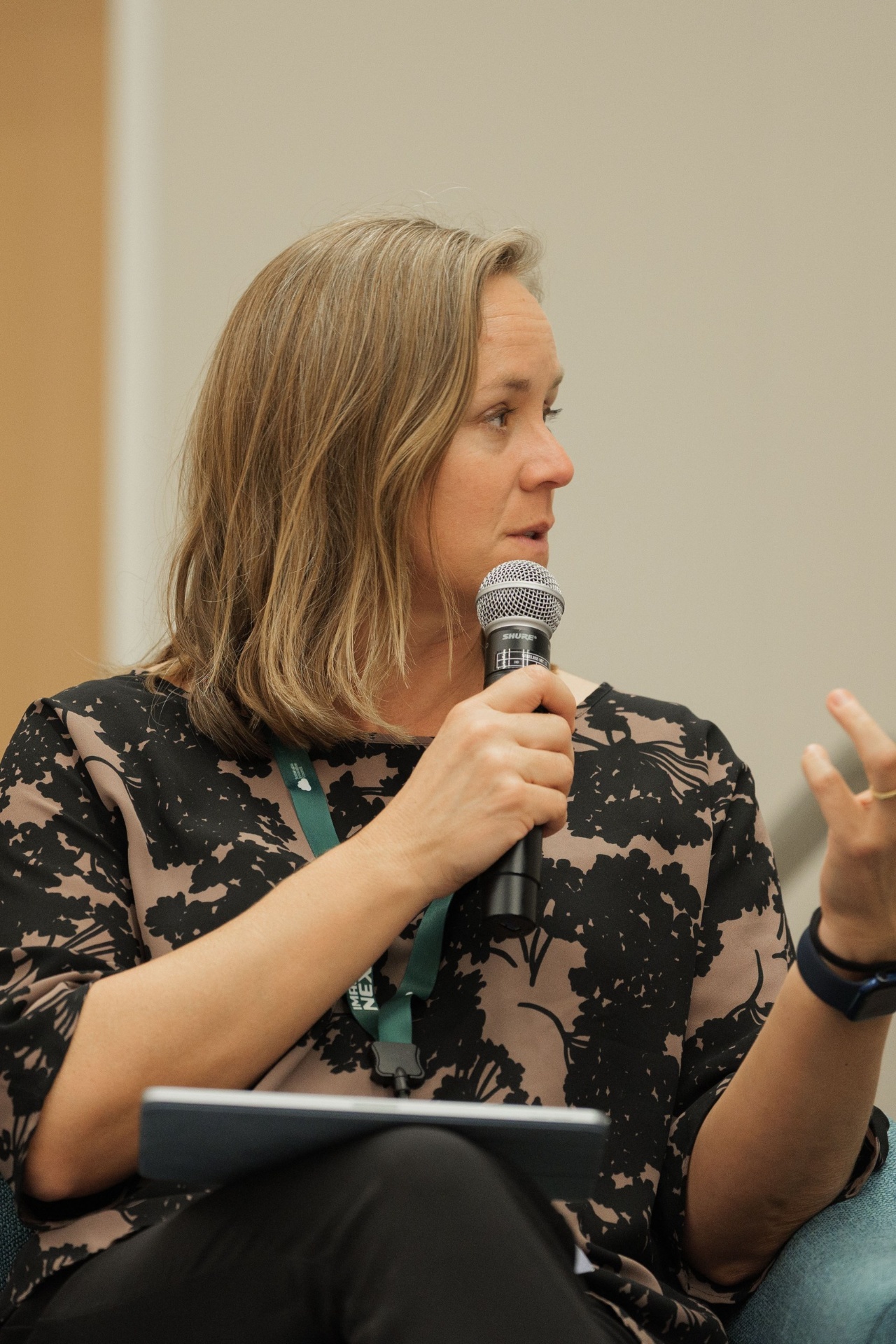 Christina Cairns moderating Capital Day Panel 5 'From Growth to Bankability', gesturing while speaking with mic on stage at UC Law SF