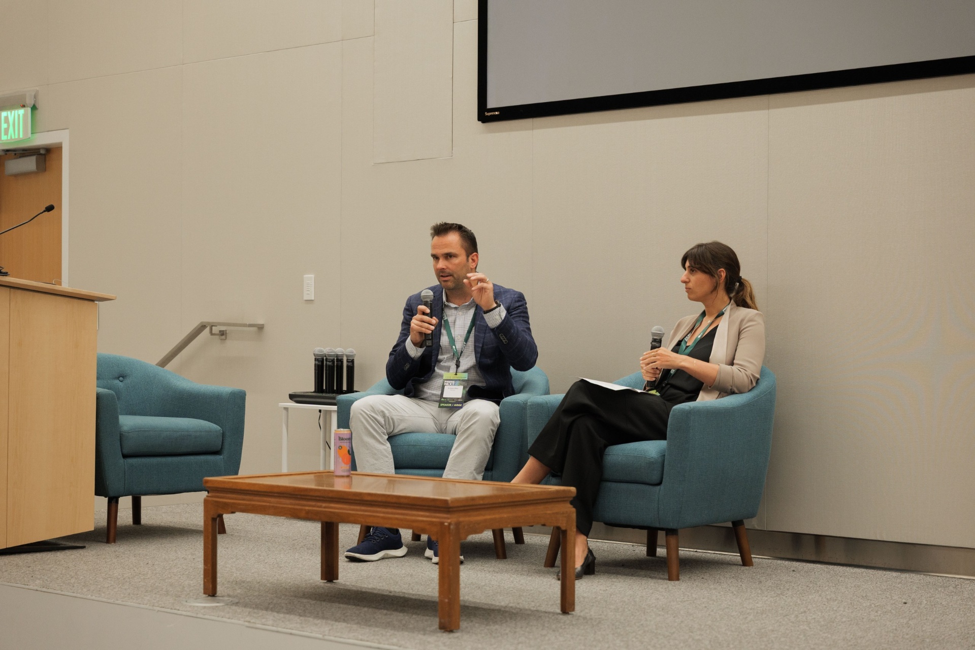 Capital Day fireside chat 'Crossing the Deployment Valley' wide stage shot — Dr. Ryan Gilliam of Fortera speaking with moderator Natalie Volpe of WOLLEMI at UC Law SF