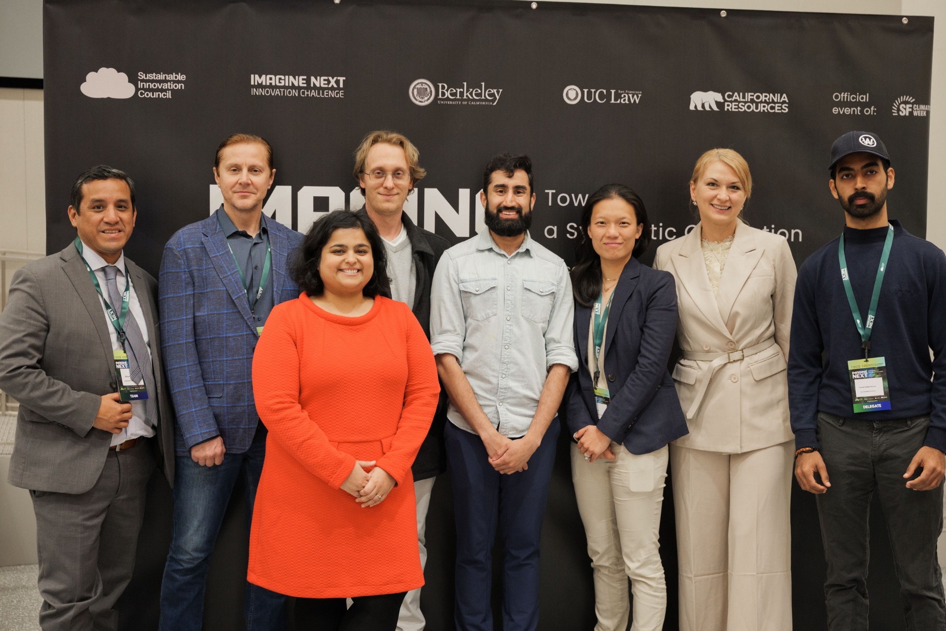 Capital Day Panel 4 'Beyond Priced Rounds' group photo — eight participants smiling together beneath the Imagine Next Innovation Challenge sponsor banner at UC Law SF