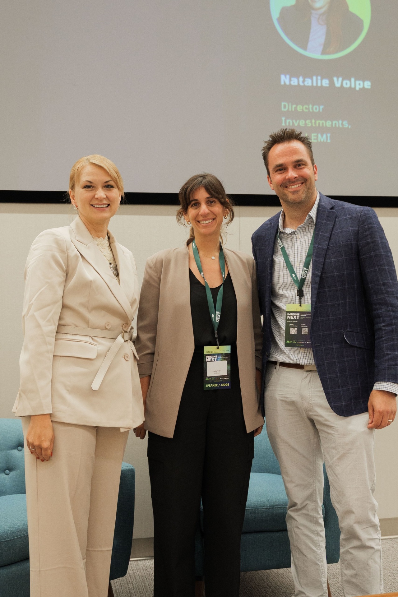 Portrait of Natalie Volpe of WOLLEMI flanked by two Imagine Next jurors on the Capital Day stage following the 'Crossing the Deployment Valley' fireside chat